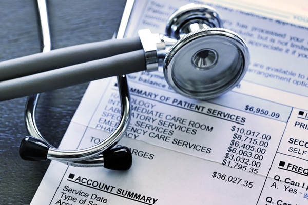 Stethoscope atop bill for medical treatment services.